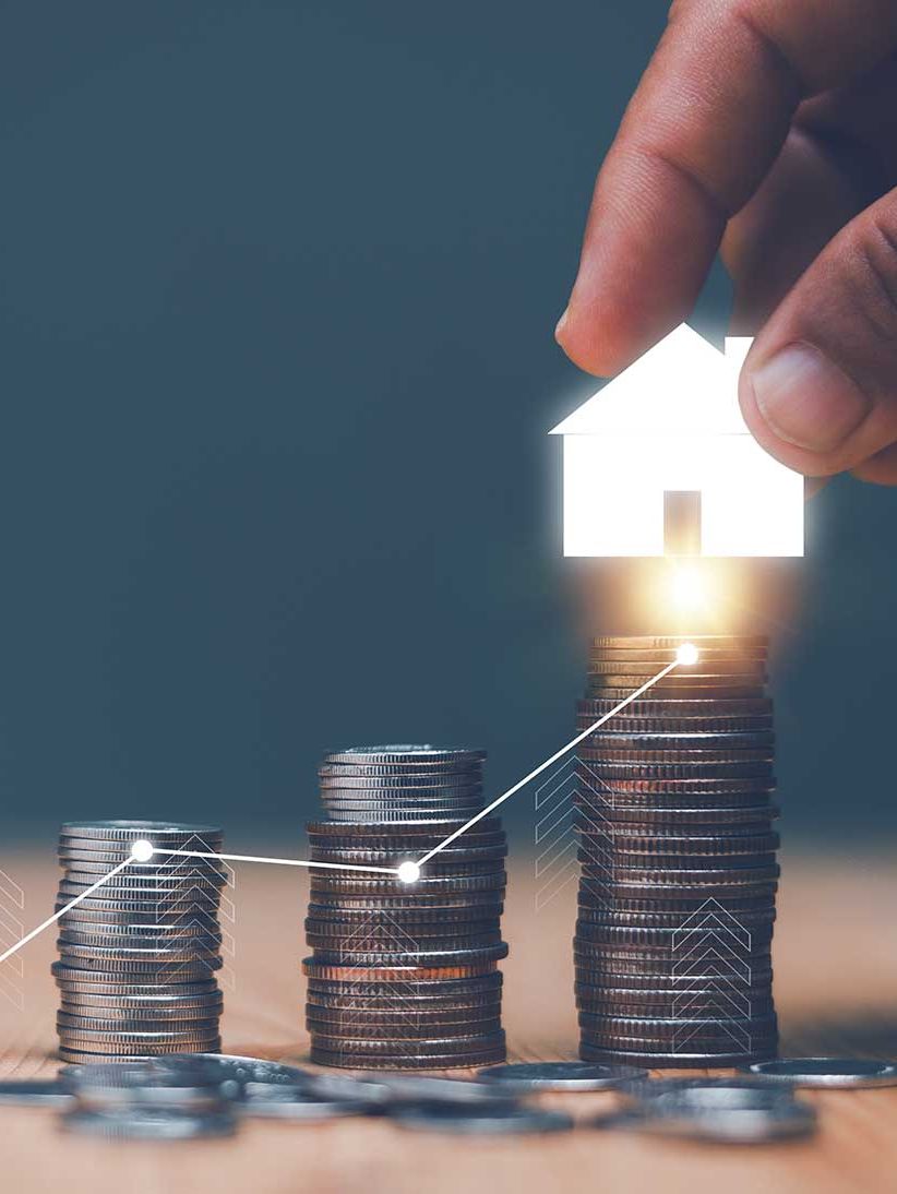 Investition für Immobilienkonzept, die Hand eines Geschäftsmannes legt das Haussymbol auf den Münzstapel und die fortschreitende Grafik